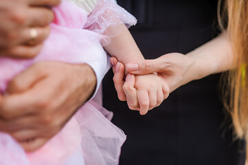 A heartfelt moment captured as a dark-skinned man and a light-skinned woman tenderly hold the tiny...