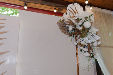 Elegant wedding backdrop with a neutral color palette featuring a lush floral arrangement of white...