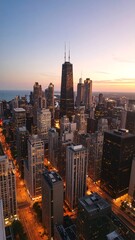 Naklejka premium Magnificent cityscape view showcases tall buildings during a tranquil twilight hour near open water.