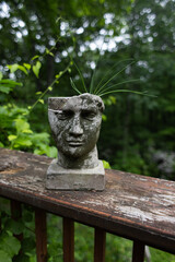 stone statue of a man's head as a plant pot