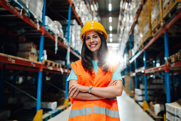 Smiling supervisor posing with crossed arms in warehouse