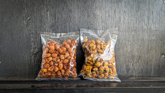 snack in clear plastic packaging on black background - Whole melinjo snack, or better known as emping melinjo, is a traditional Indonesian snack made from melinjo seeds that are fried dry until crispy