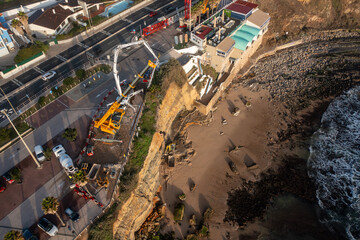 Fototapeta na wymiar High angle drone shot of shoreline stabilization work with construction vehicles highlighting coastal development and infrastructure projects in city