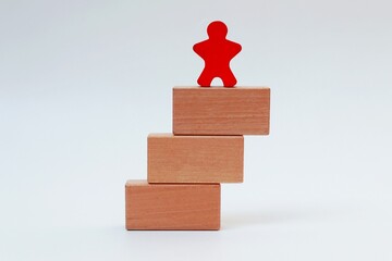 Stack of wooden blocks and human icon on top on white background © Isman