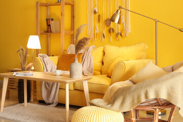 Interior of stylish living room with cozy yellow sofa and glowing lamps