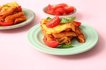 Plates of pasta with tomato sauce and cheese on pink background