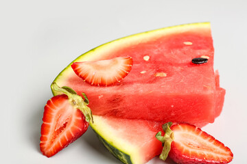 Pieces of fresh watermelon and strawberries on grey background