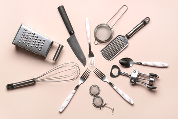 Set of different kitchen utensils on beige background