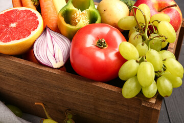 Wooden box with different fresh fruits and vegetables, closeup
