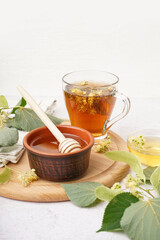Bowl with linden honey and glass cup of tea on white background
