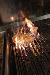 beef steak sizzling on an open flame grill