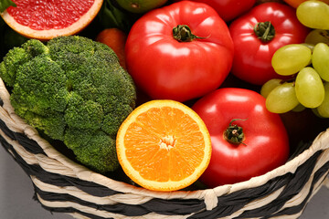 Wicker bowl with different fresh fruits and vegetables, closeup