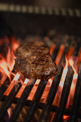 beef steak sizzling on an open flame grill