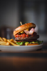 delicious beef burger with fresh vegetables, and sesame bun, served with golden fries, ideal for food and restaurant visuals