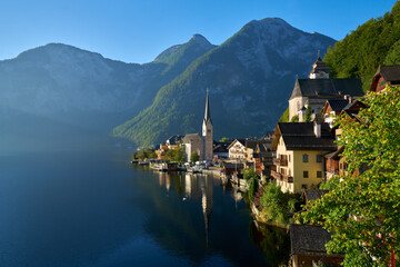 Hallstatt Calm Misty Alpine Morning Austria. Blue sky and morning mist at beautiful Hallstatt village on Hallstatter Lake in the Austrian Alps in the region of Salzkammergut, Austria.

