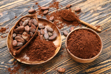 Bowl with cocoa powder and beans on wooden background