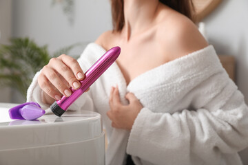 Woman with vibrator and anal plug in bathroom, closeup