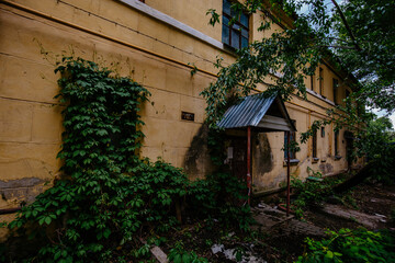 Fototapeta premium Old overgrown house in ghost town
