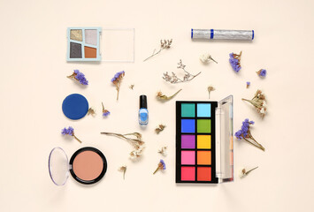 Composition with different makeup products and beautiful flowers on light background