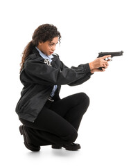 African-American female police officer with gun on white background