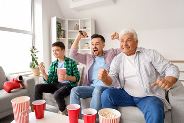 Obraz premium Teenage boy with his dad and grandfather on sofa at home