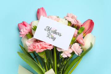 Bouquet of different beautiful flowers with greeting card on blue background. Mother's Day...