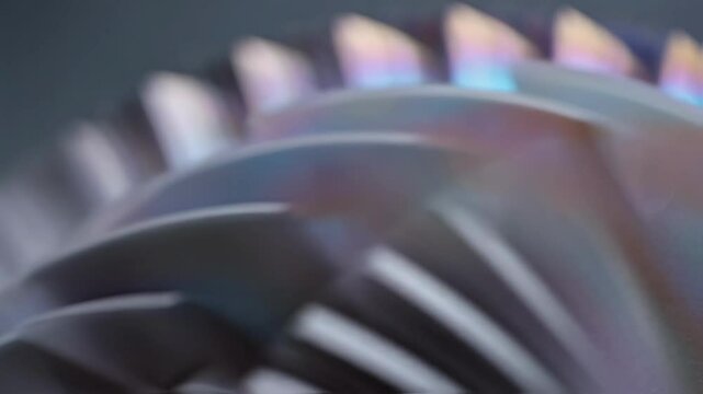 Shimmering cermet nanopebbles coat turbine blades, their textured surface and intricate design highlighted by colorful reflections in a technological showcase