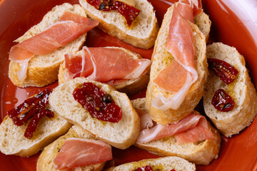 Delicious baguette slices topped with prosciutto and sun-dried tomatoes