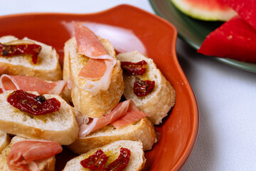 Delicious baguette slices topped with prosciutto and sun-dried tomatoes