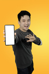 man showing smartphone with blank screen on bright yellow background