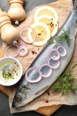 Tasty herring with spices on black table, flat lay