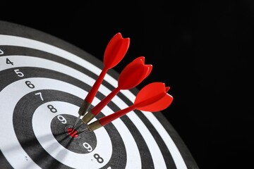 Targeting. Dart board with arrows on black background, closeup