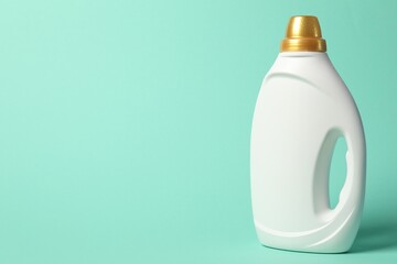 Bottle of fabric softener on turquoise background, space for text