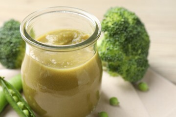 Baby food. Tasty puree in glass jar and ingredients on table, closeup. Space for text