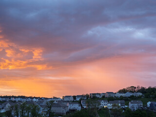 Vivid sunrise colors illuminate clouds over suburban houses outside Pittsburgh
