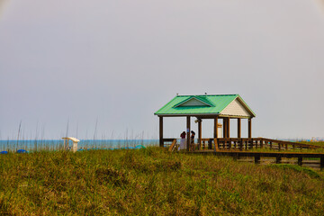 A view of a large gazebo surrounded by dune grass by the ocean at Carolina Beach in North Carolina...