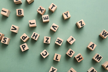 Wooden cubes with English letters on green background