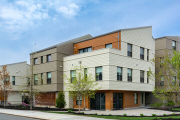 Modern residential complex with beige and orange cladding on a spring day in Brighton, Massachusetts, USA
