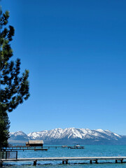 Stunning landscape of Lake Tahoe featuring crystal-clear turquoise water, rustic wooden piers and...