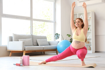 Obraz premium Sporty pregnant woman training on mat at home