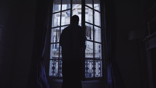Man opening french window in paris apartment