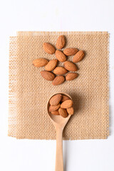 Raw almond nut seed in wooden spoon, Top view