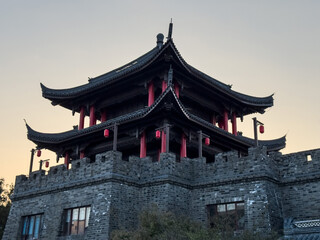 Fototapeta premium Majestic Ancient Pagoda Surrounded by Twilight Hues and Historic Stone Walls