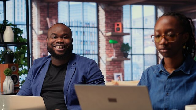 African american couple work on a management project together, using a laptop to research business trends and manage an online brand. Successful remote career development as a team. Camera B. - Powered by Adobe