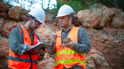 Expert geologists are working together to examine minerals in different layers of rock on a...