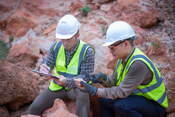 Expert geologists are working together to examine minerals in different layers of rock on a...