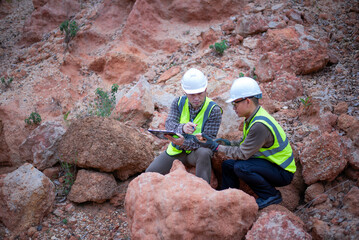 Expert geologists are working together to examine minerals in different layers of rock on a...
