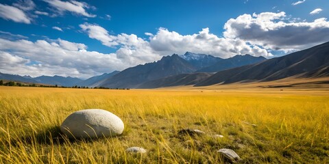 Serene Mountain Valley Landscape with Large Boulder in Golden Grassland