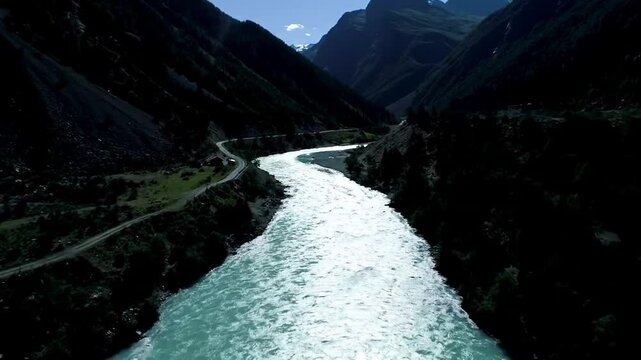 Majestic River Flowing Through A Valley Amidst Mountainous Terrain