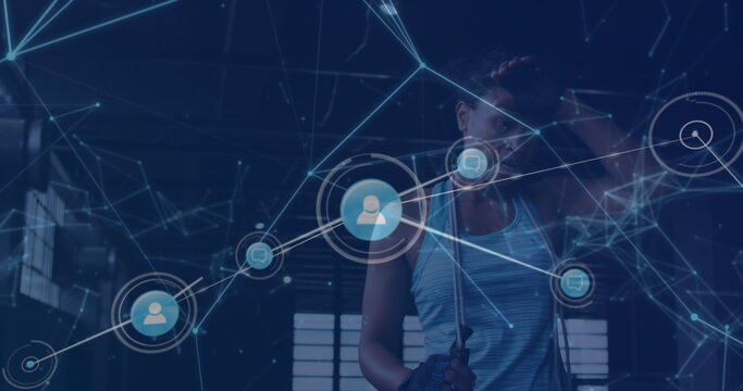 Network of digital icons against tired african american fit woman taking a break at the gym